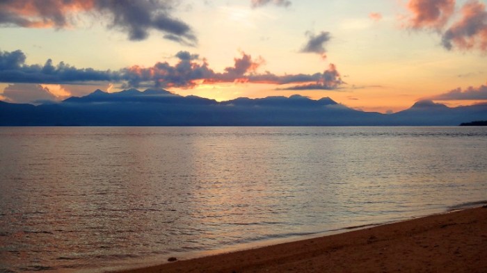 The sun coming out from Biliran mainland's mountains, as seen from Higatangan Island sand bar - Philippines